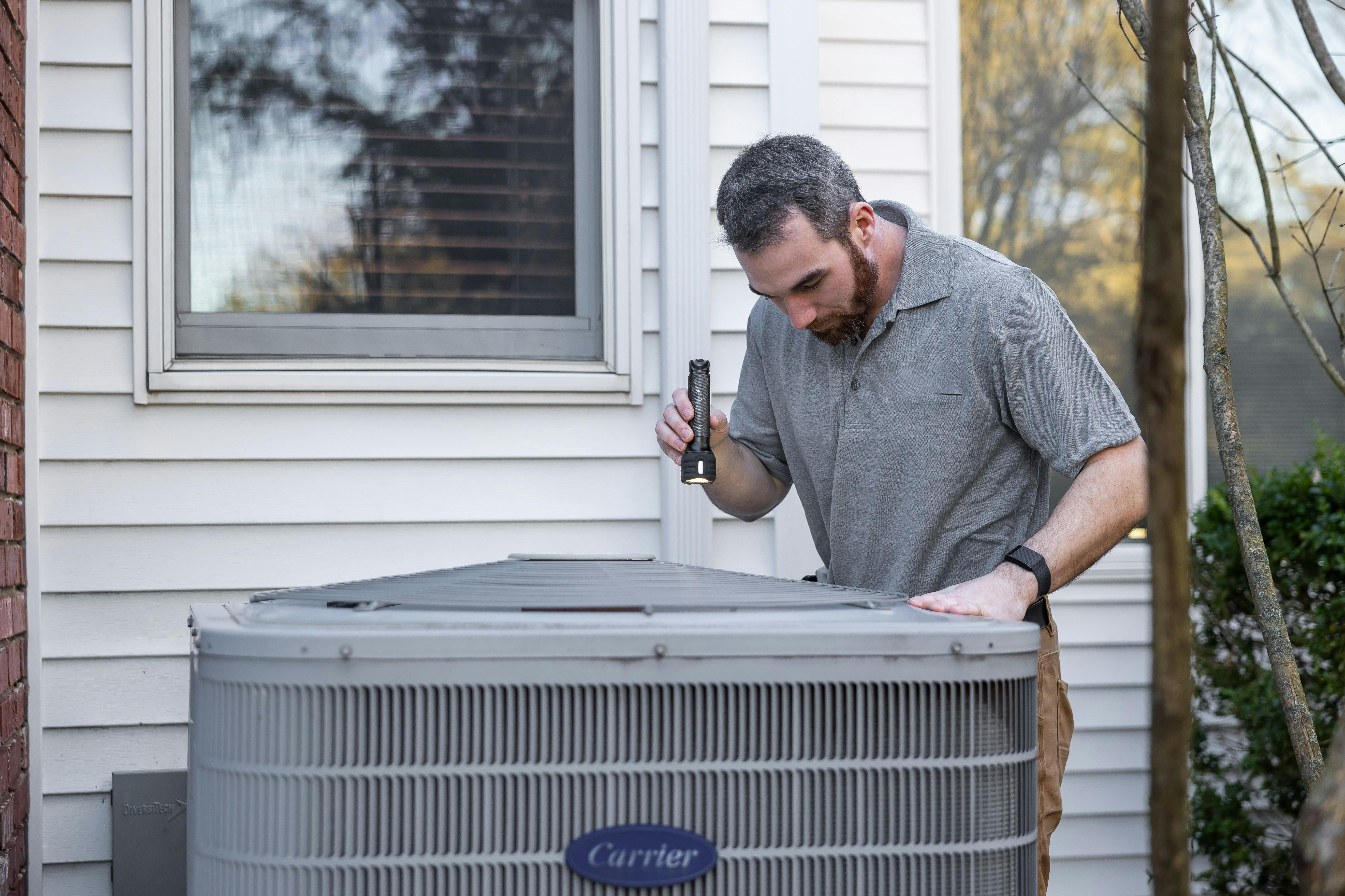 HVAC technician inspecting AC unit